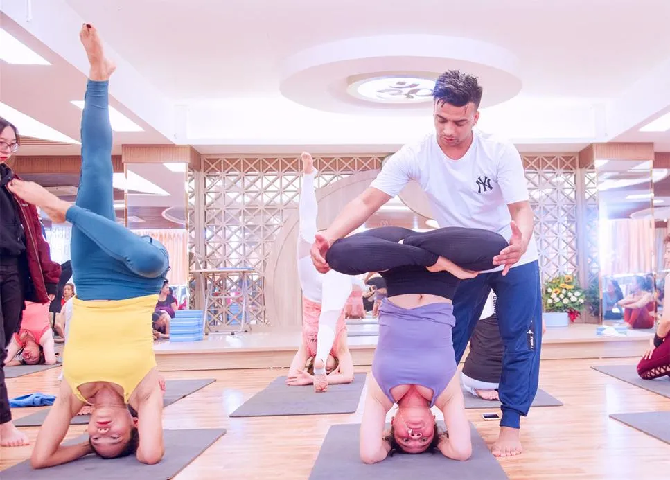 Một người phụ nữ thực hiện bước chuẩn bị để trồng cây chuối, hình ảnh minh họa hướng dẫn chi tiết cách tập yoga trồng cây chuối